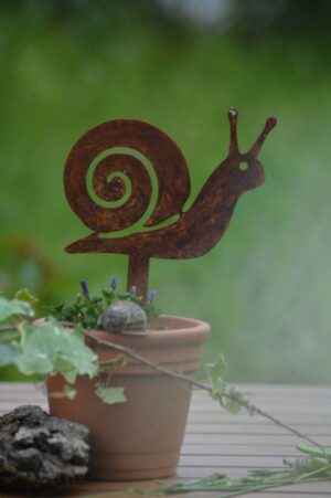 Pic escargot en métal rouillé planté dans un pot de fleurs avec une plante verte