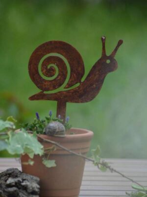 Pic escargot en métal rouillé planté dans un pot de fleurs avec une plante verte